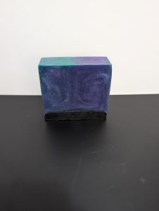 Square soap bar with a mix of Green, Purple (swirled together) and Black.