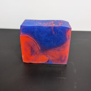 Square soap bar with a mix of blue and red swirling together.